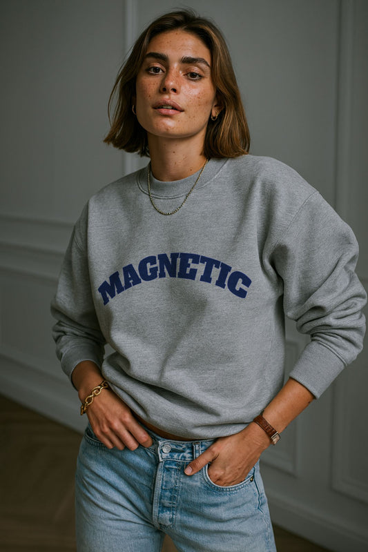 Model wearing FineAF Magnetic Grey Sweatshirt in organic cotton, styled with light denim jeans in studio daylight