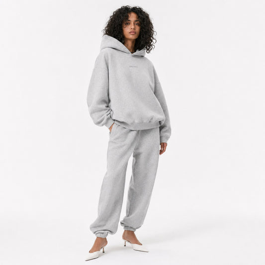 Three-quarter editorial view of the FineAF Magnetic heather grey oversized hoodie and matching joggers