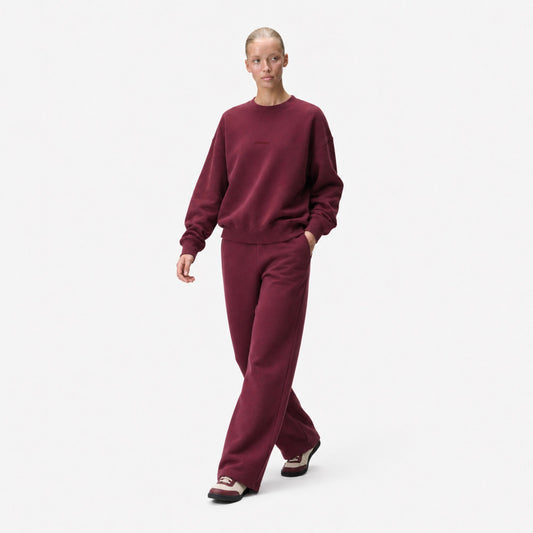 Woman walking in the FineAF Visionary wine sweatshirt and matching sweatpants set