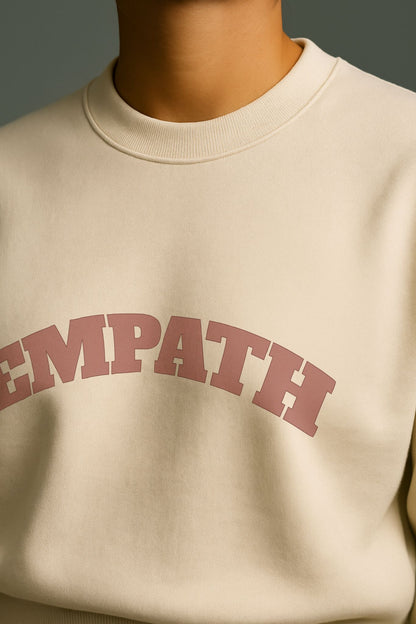 Close-up of EMPATH text print in dusty rose on ivory organic cotton sweatshirt, FineAF collection.