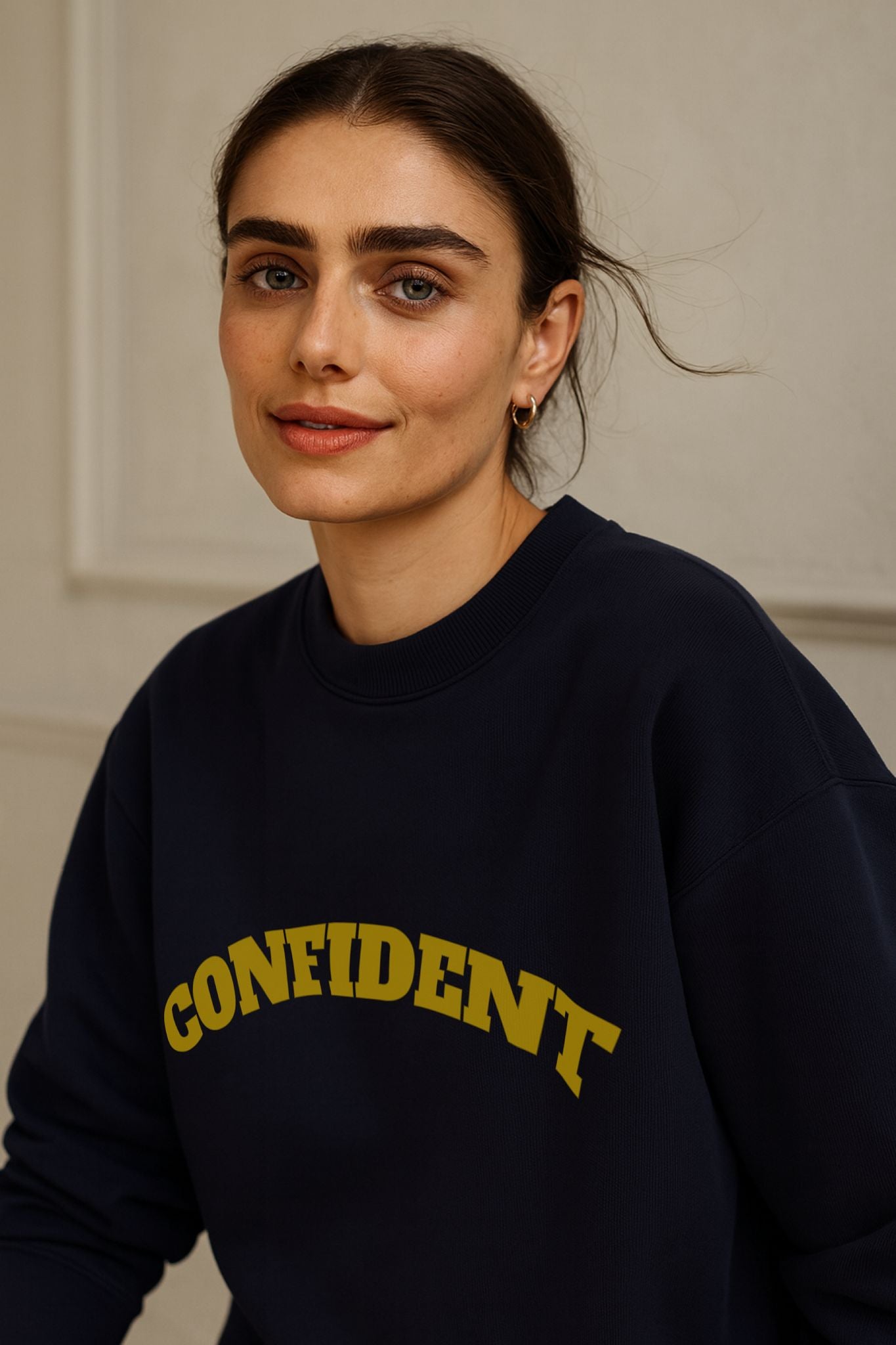 FineAF CONFIDENT sweatshirt in deep navy, organic cotton fleece, worn with jeans in modern editorial daylight.