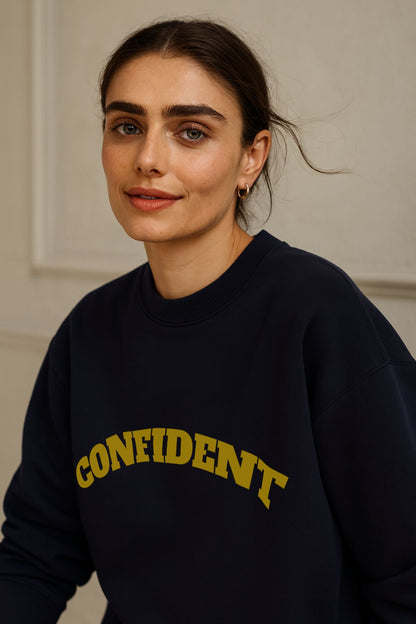 FineAF CONFIDENT sweatshirt in deep navy, organic cotton fleece, worn with jeans in modern editorial daylight.
