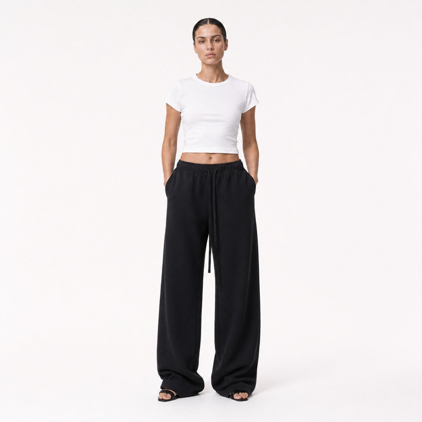 Woman wearing the white FineAF Cropped Tee with black wide-leg pants, front view