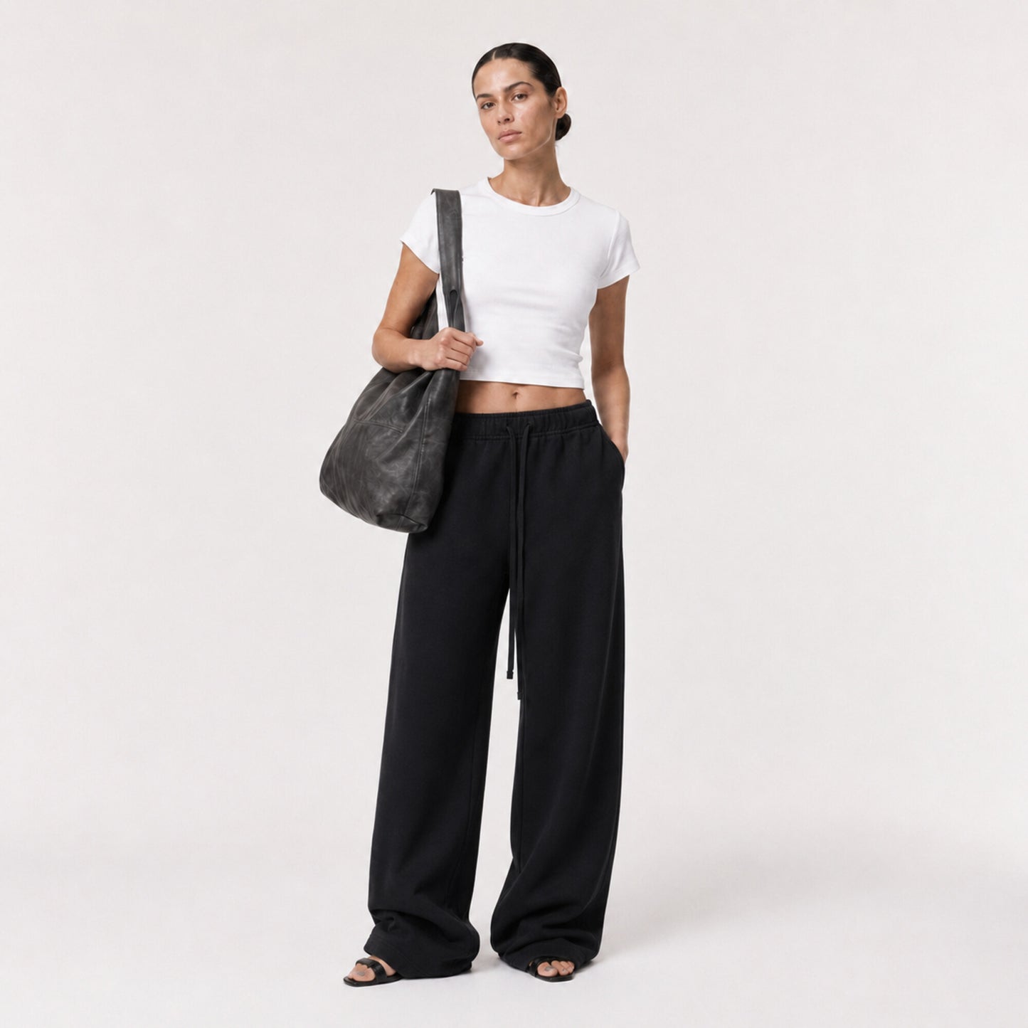 White FineAF Cropped Tee styled with black wide-leg pants, three-quarter view