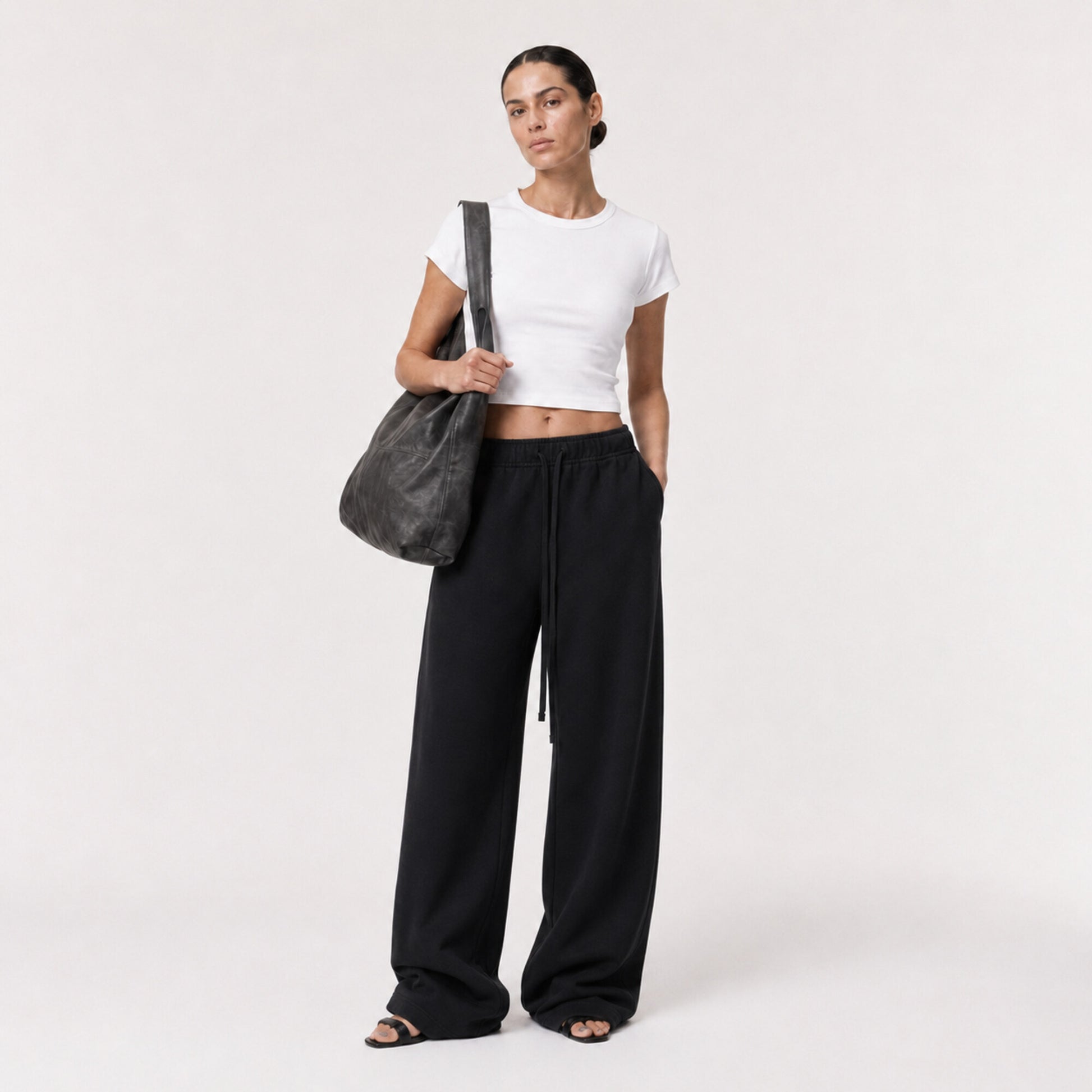 White FineAF Cropped Tee styled with black wide-leg pants, three-quarter view