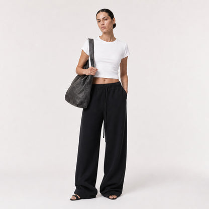 White FineAF Cropped Tee styled with black wide-leg pants, three-quarter view