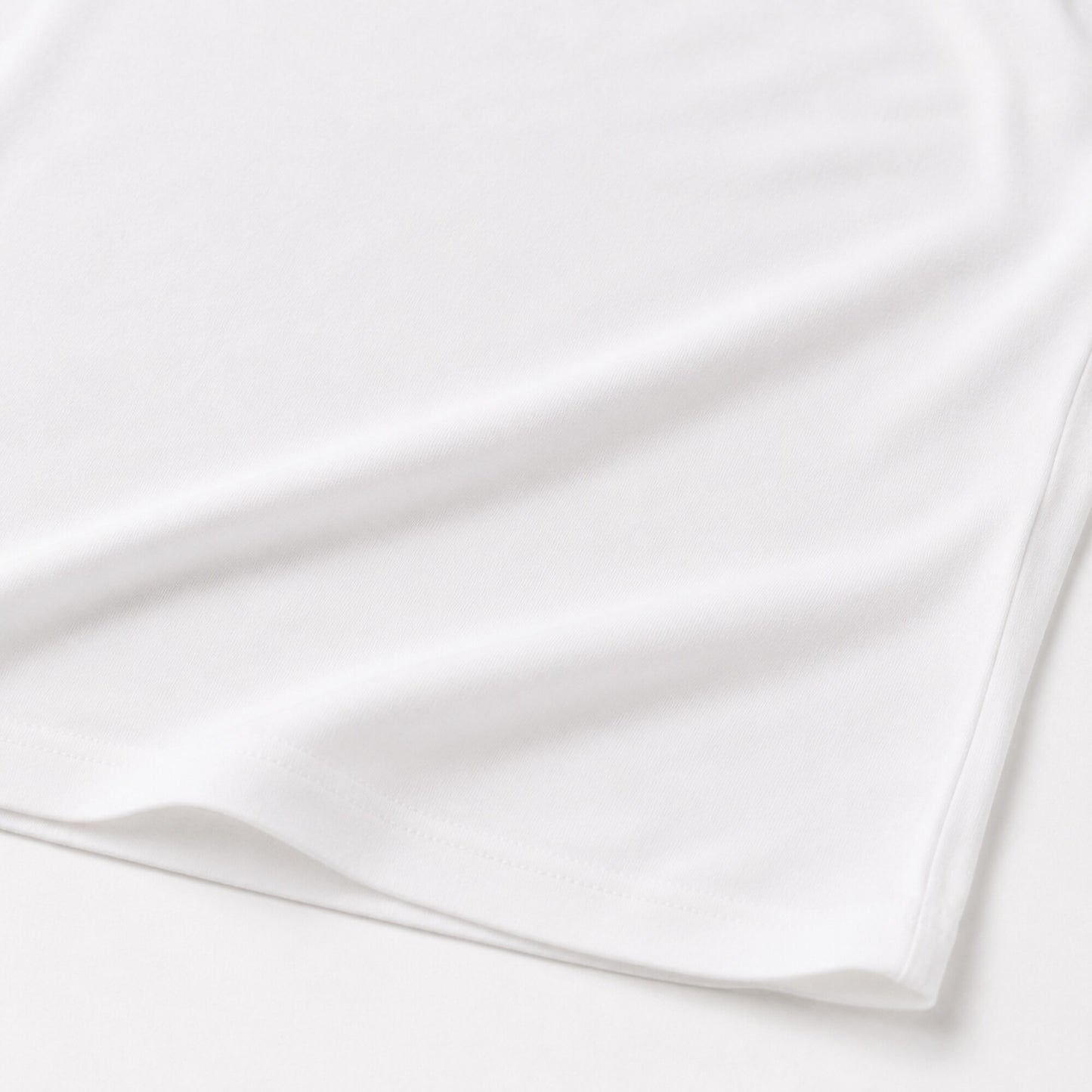 Close-up of the white FineAF Cropped Tee hem and side seam construction
