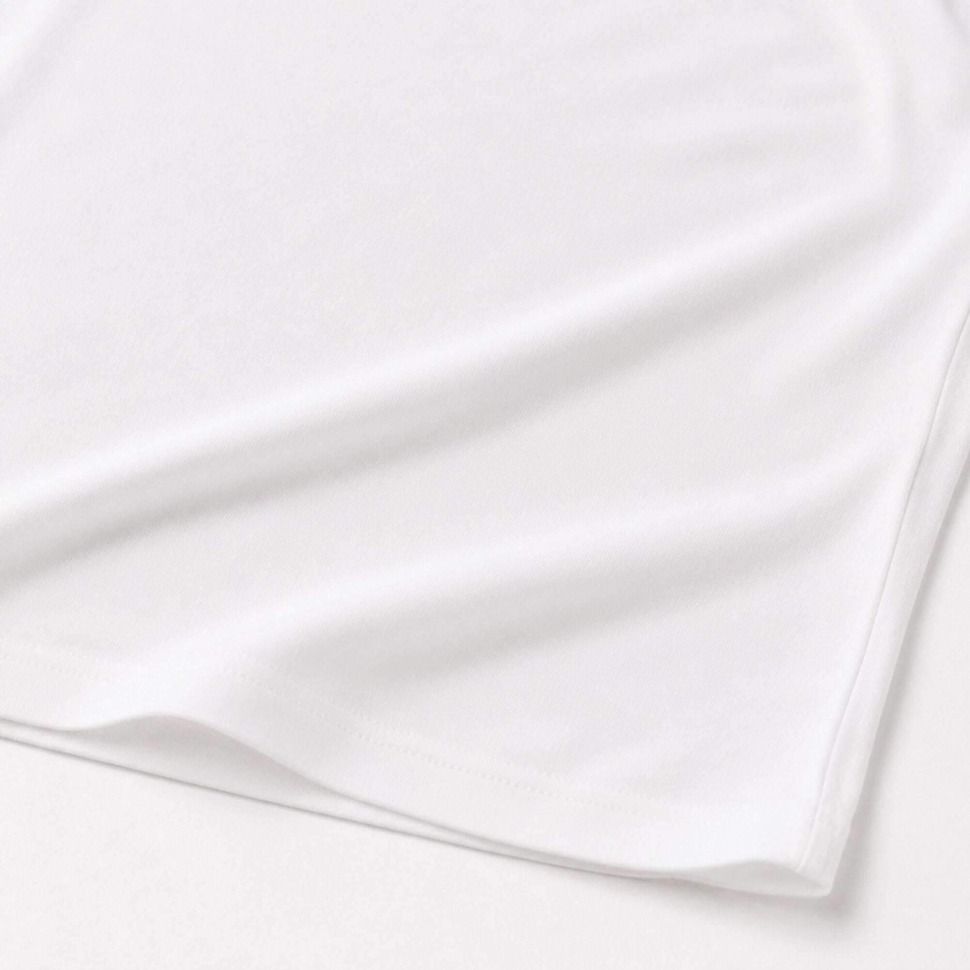 Close-up of the white FineAF Cropped Tee hem and side seam construction