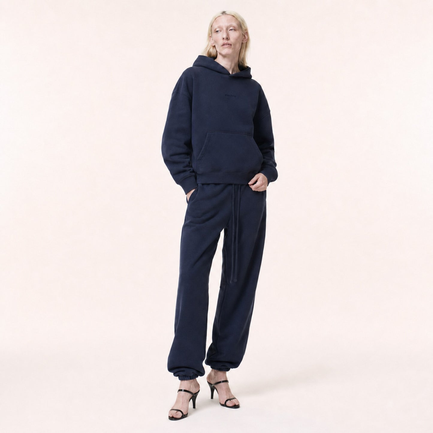 Woman wearing the FineAF Electric deep navy heavyweight hoodie and matching joggers, front view