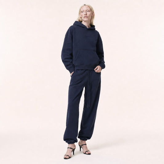 Woman wearing the FineAF Electric deep navy heavyweight hoodie and matching joggers, front view