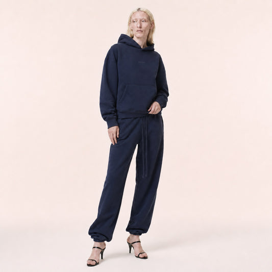 Woman wearing the FineAF Electric deep navy heavyweight hoodie set in an editorial three-quarter pose