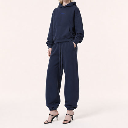 Three-quarter view of FineAF Electric deep navy pants with a gathered waistband, long welt pockets and elastic ankles.