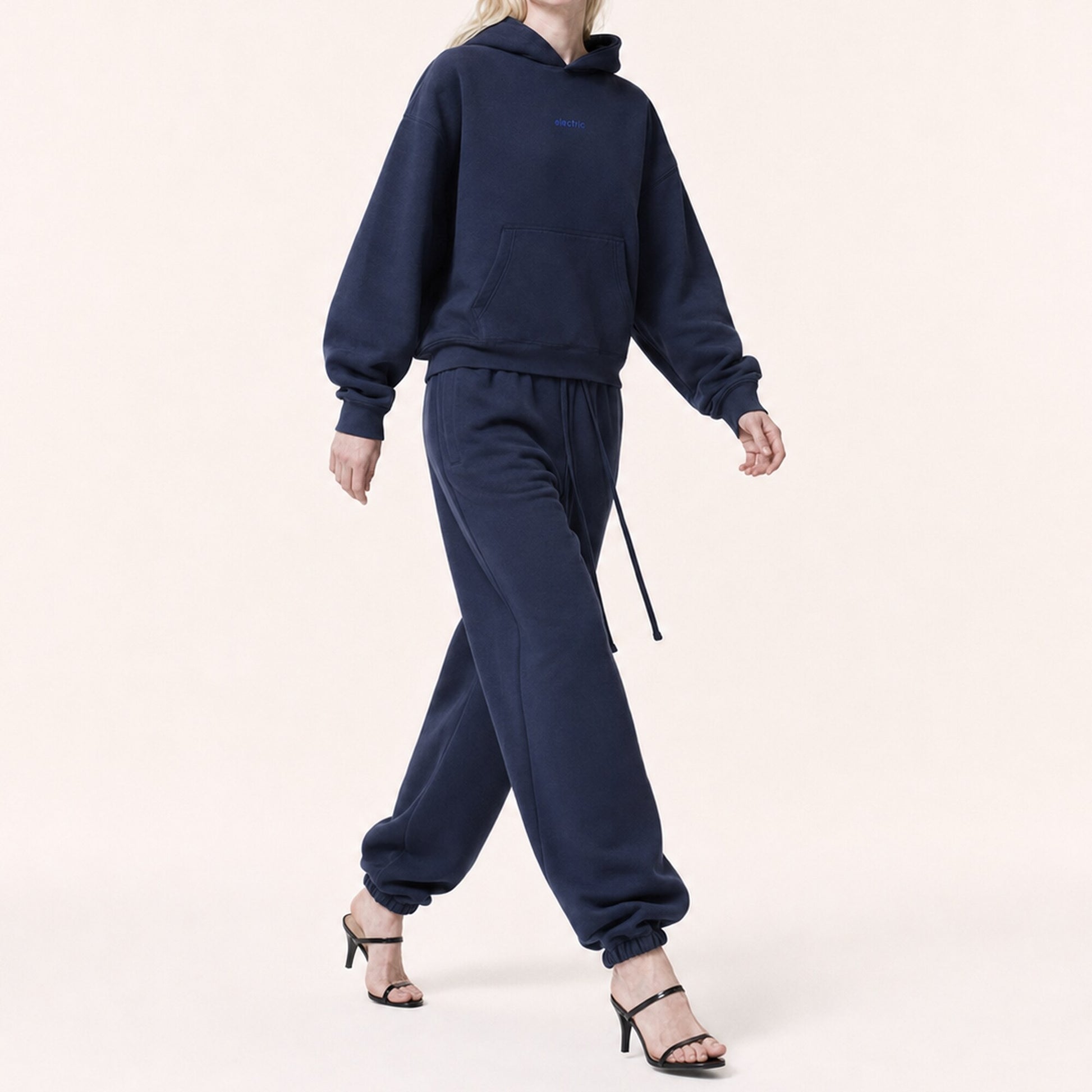 Woman walking in FineAF Electric deep navy oversized pants, showing the structured balloon drape and gathered ankles.