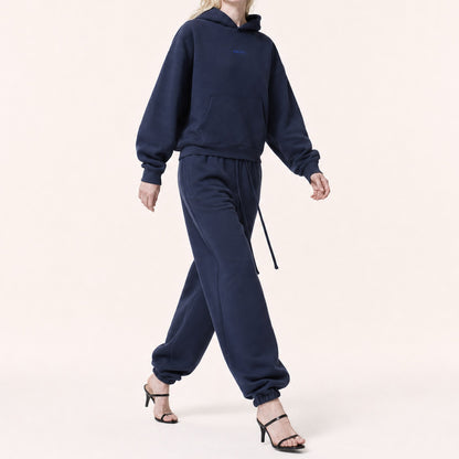 Woman walking in FineAF Electric deep navy oversized pants, showing the structured balloon drape and gathered ankles.