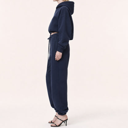 Side view of FineAF Electric deep navy pants showing the mid waist, roomy hip, side seam and tapered elastic ankle.