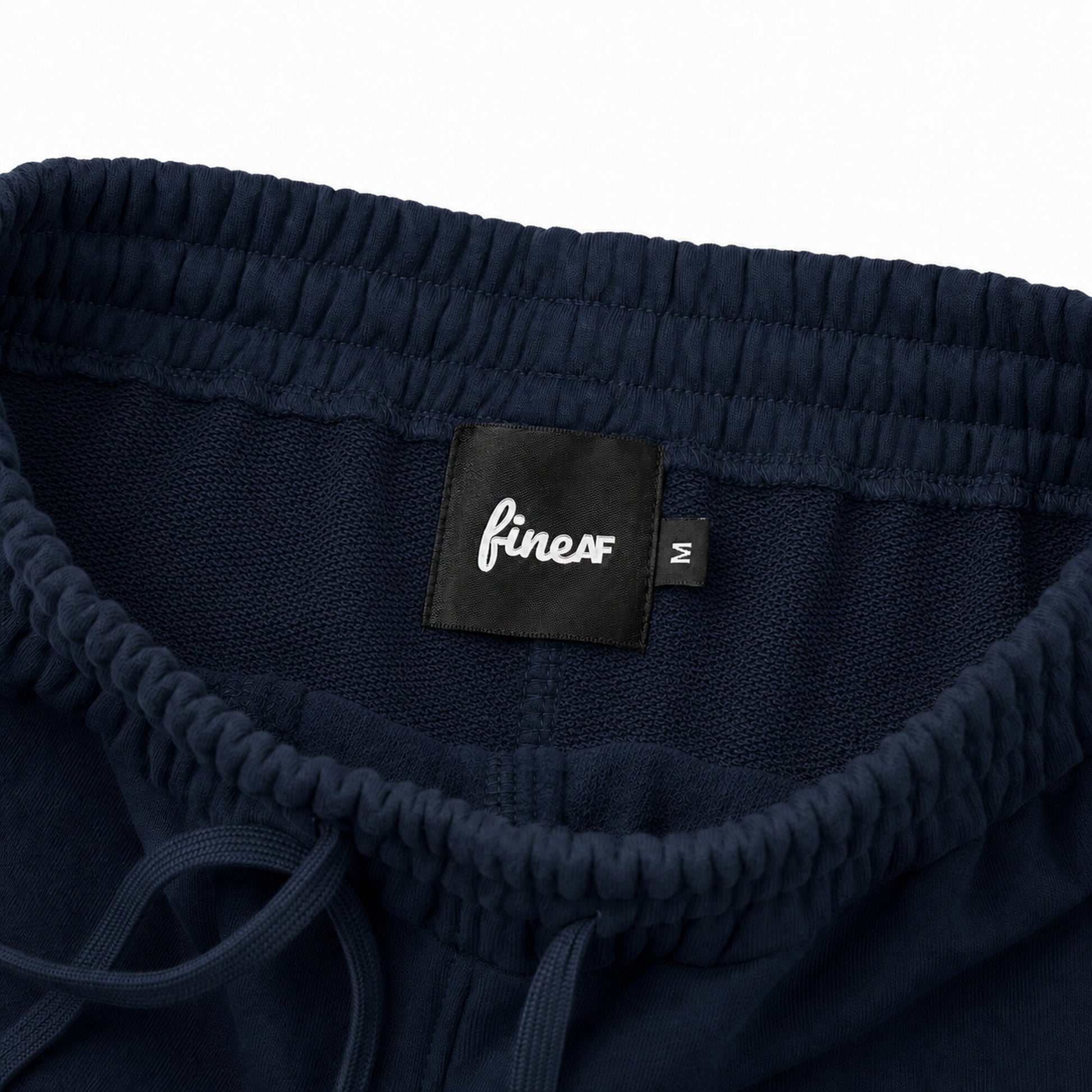 Inside waistband of FineAF Electric navy pants with loopback knit, black FineAF label and M size tab.