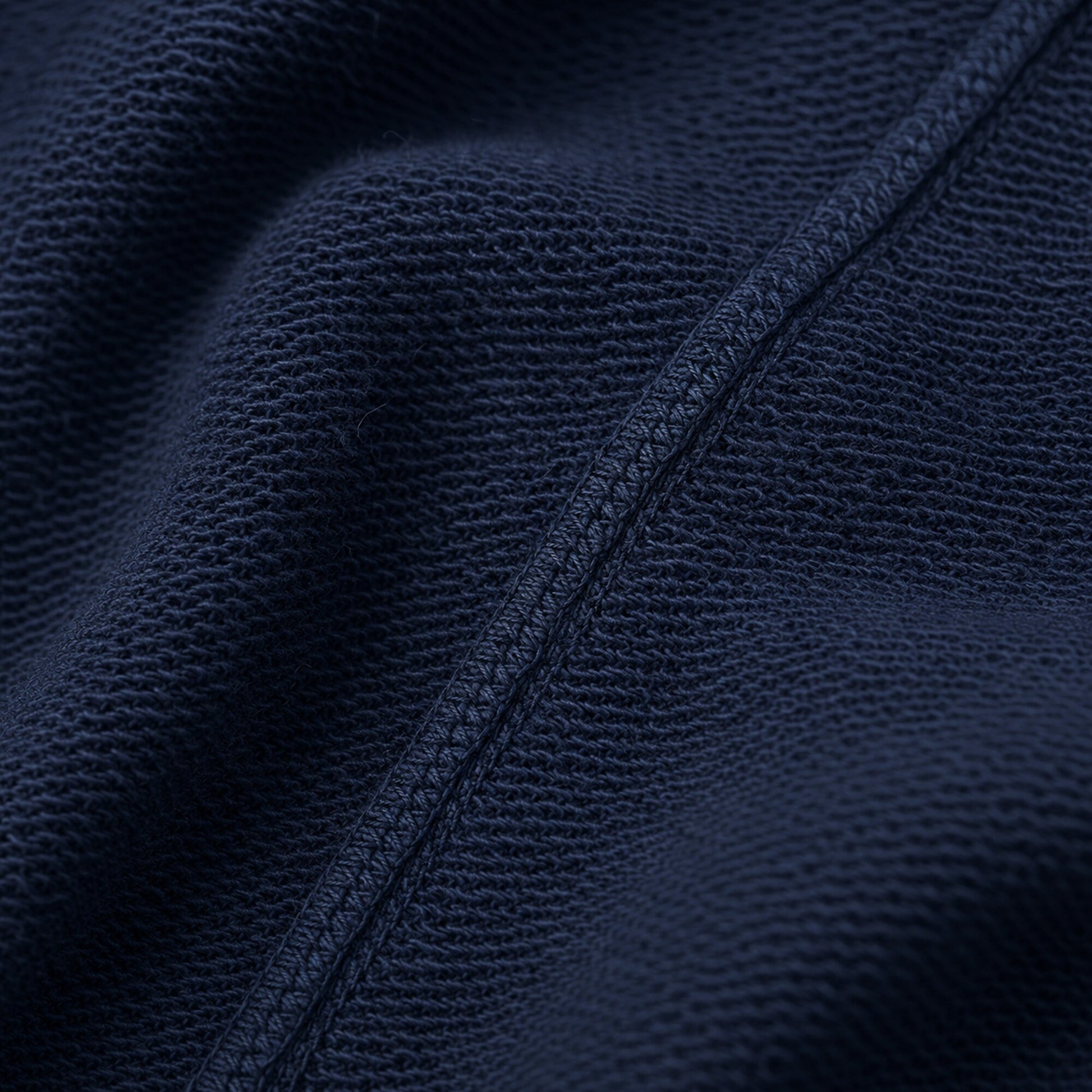 Macro of FineAF Electric navy loopback knit fabric and a tonal overlock construction seam.