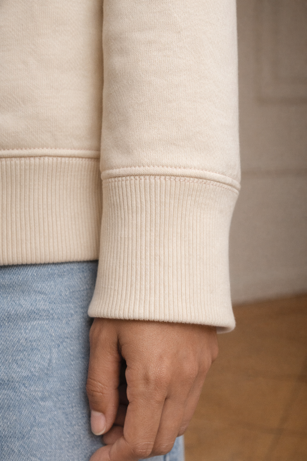 Ivory FineAF crewneck sweatshirt cuff detail close-up showing ribbed sleeve hem.