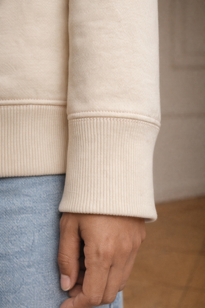 Ivory FineAF crewneck sweatshirt cuff detail close-up showing ribbed sleeve hem.