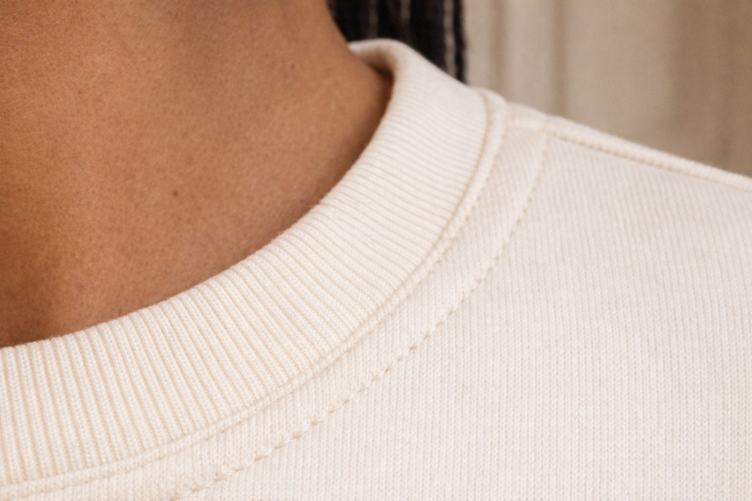 Ivory FineAF crewneck sweatshirt neckline detail close-up showing ribbed collar and stitching.