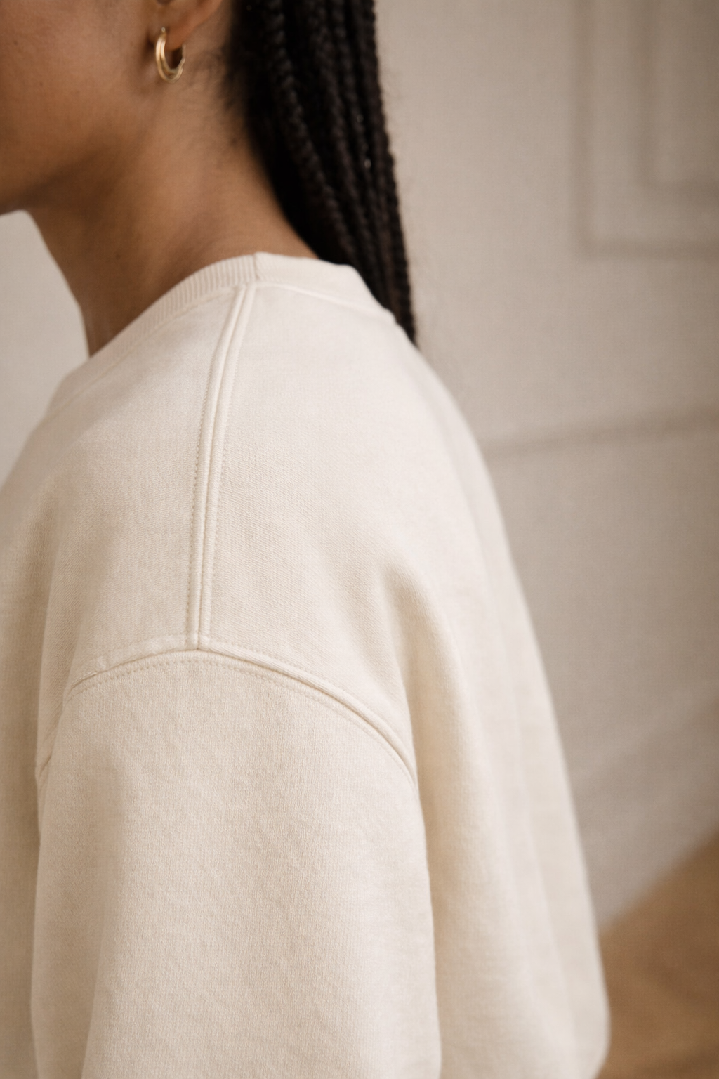 Ivory FineAF crewneck sweatshirt side/shoulder detail photo showing sleeve seam and fit.