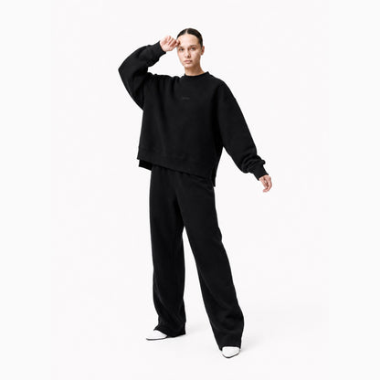 Model in the FineAF Iconic black crewneck sweatshirt showing its wide dropped shoulders and heavyweight sleeve volume.