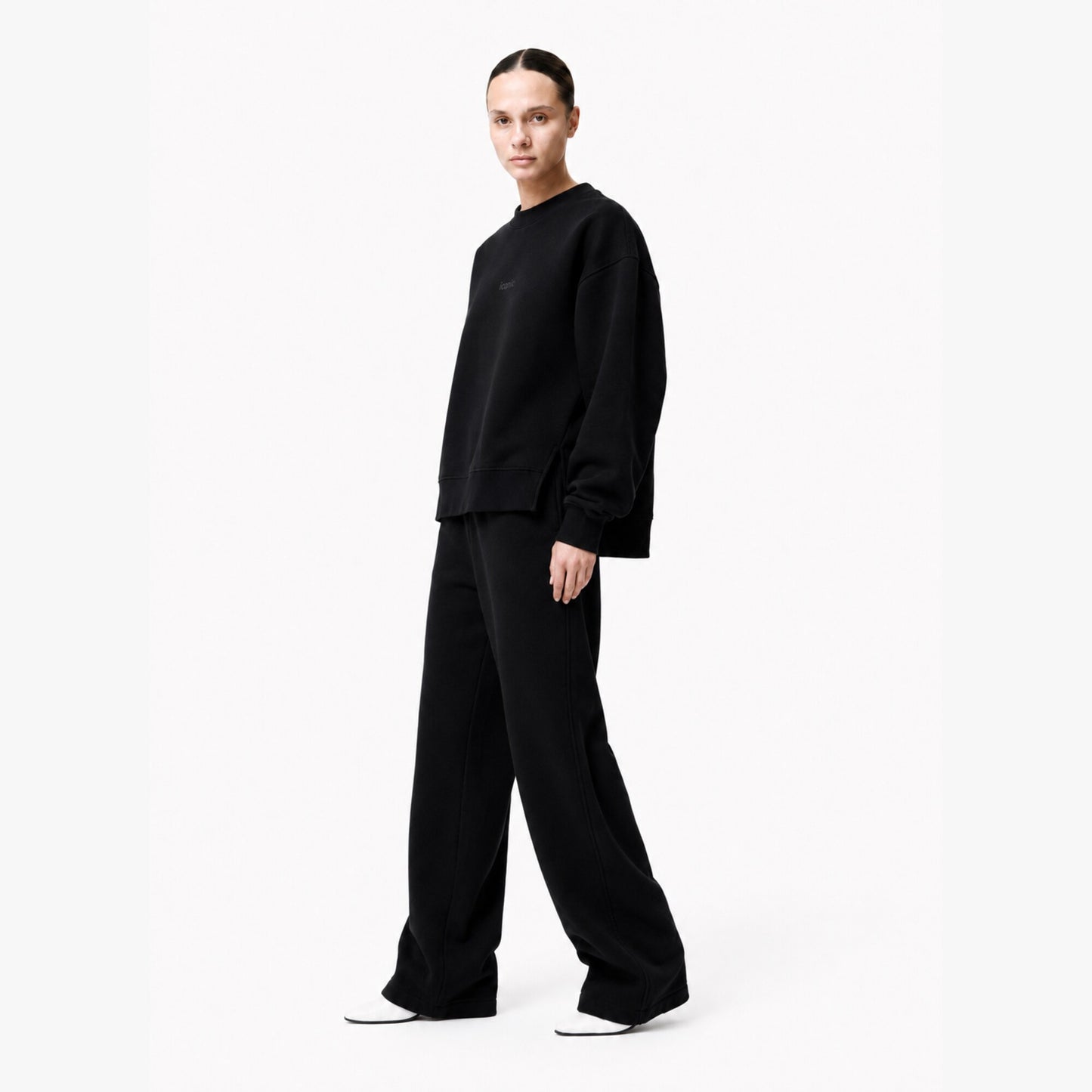 Side view of the FineAF Iconic black crewneck sweatshirt showing the short side slit and longer back hem.