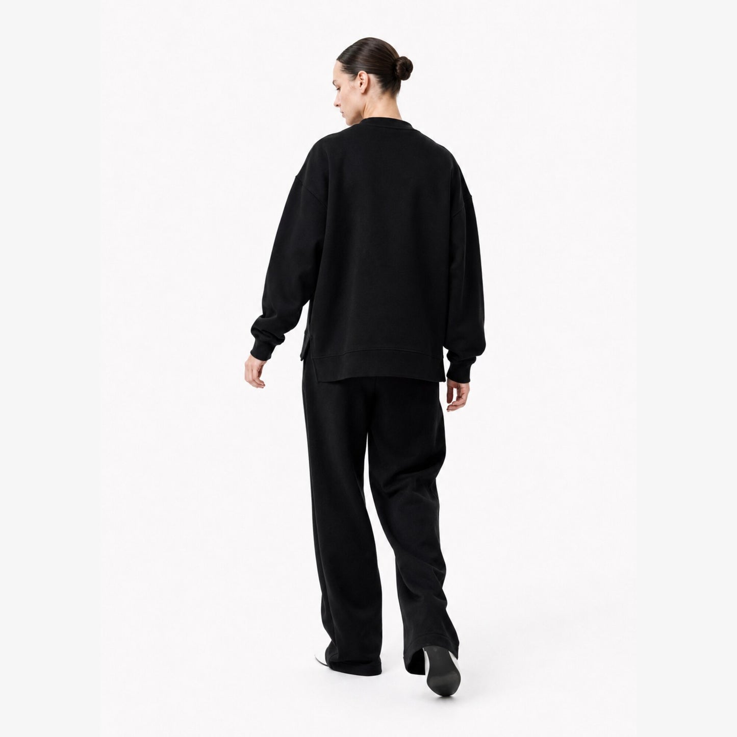 Moving back view of the FineAF Iconic black oversized crewneck sweatshirt with a clean unprinted back.