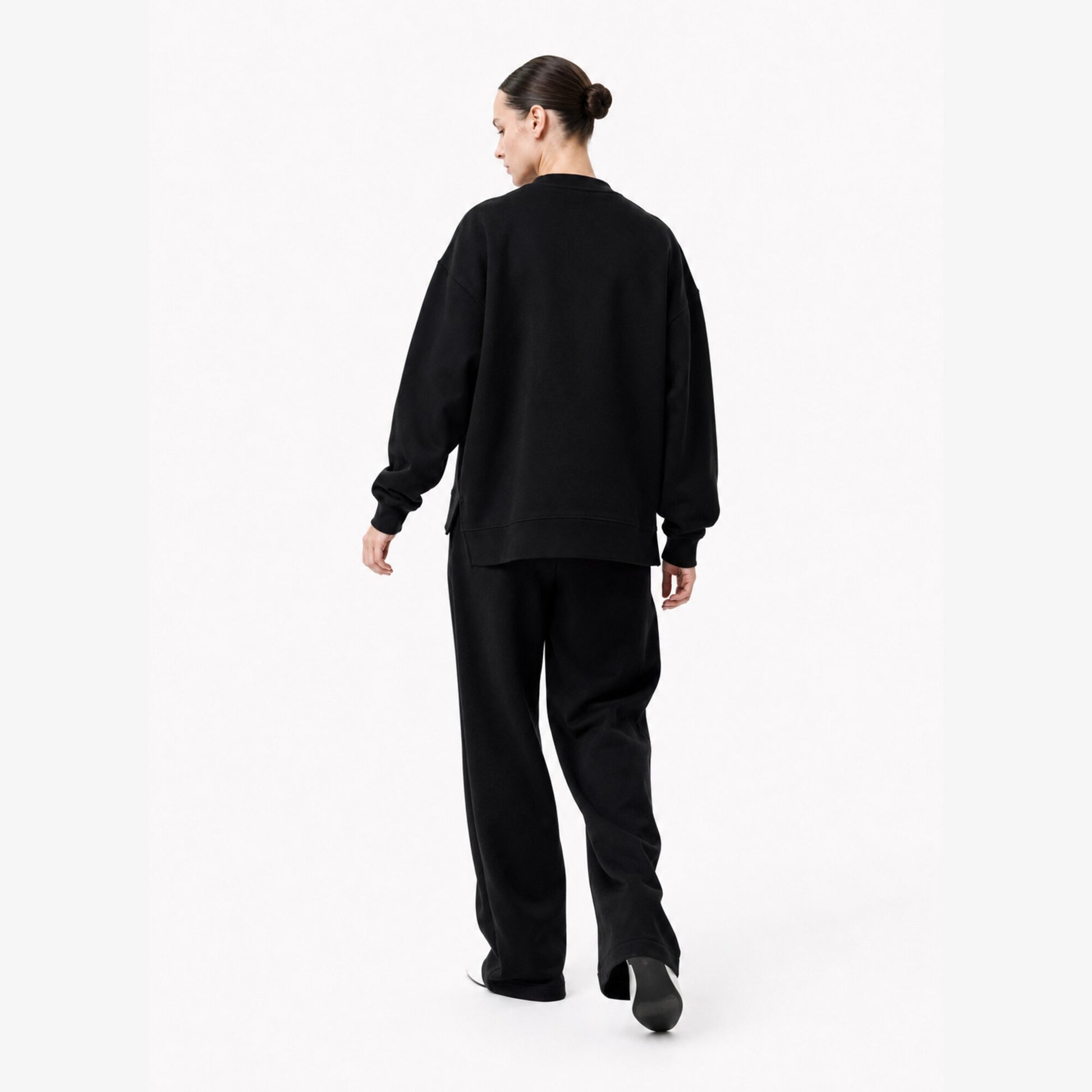 Moving back view of the FineAF Iconic black oversized crewneck sweatshirt with a clean unprinted back.