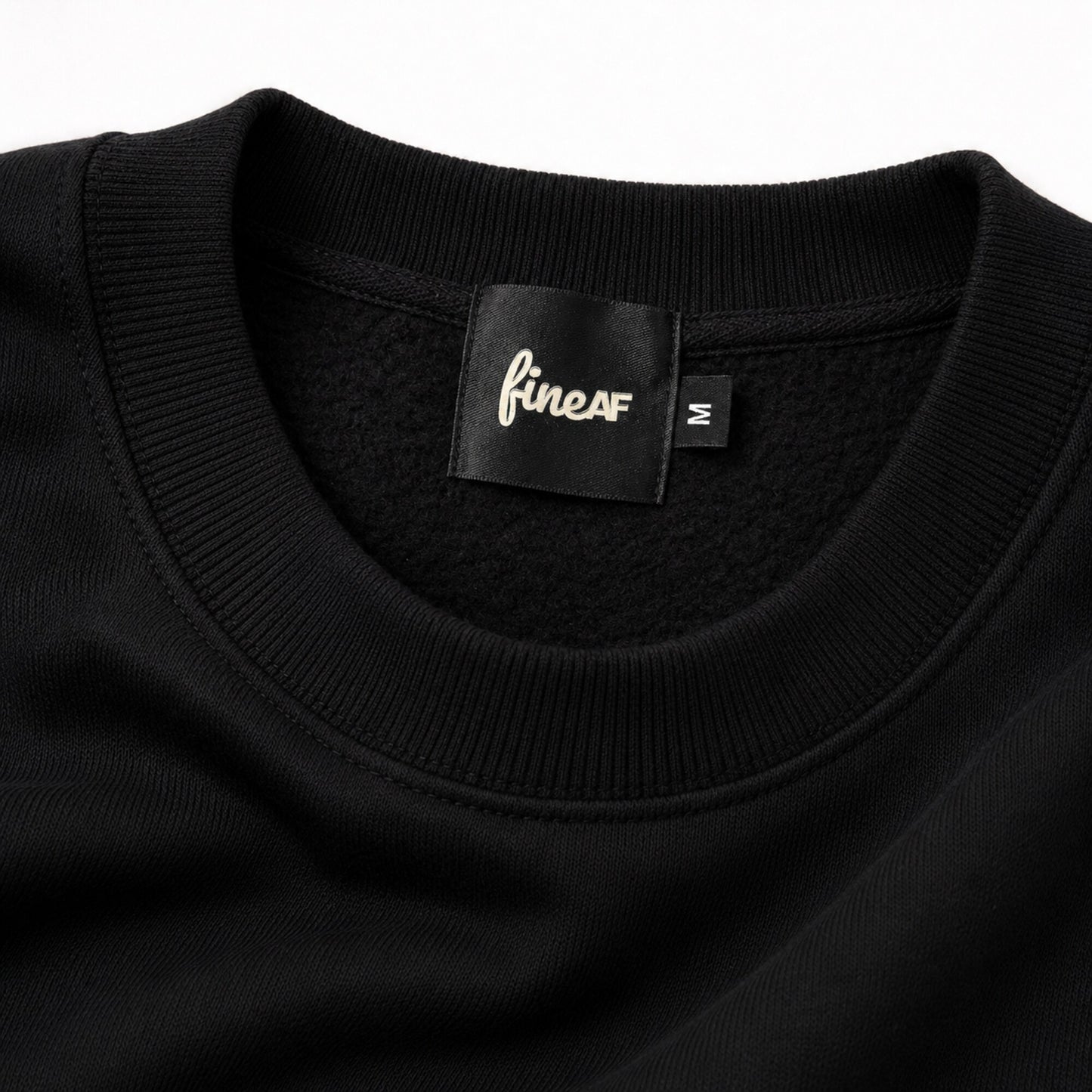 Close-up of the FineAF Iconic black sweatshirt ribbed neckline, brushed fleece interior and black FineAF size M label.