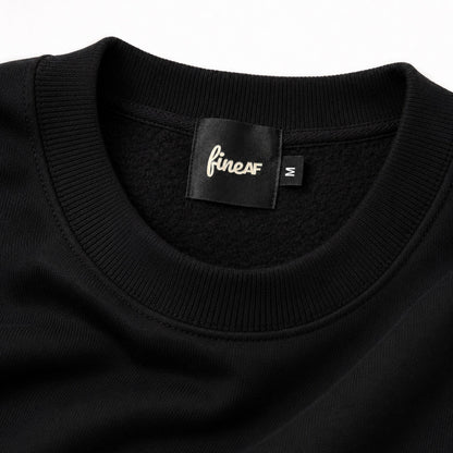 Close-up of the FineAF Iconic black sweatshirt ribbed neckline, brushed fleece interior and black FineAF size M label.