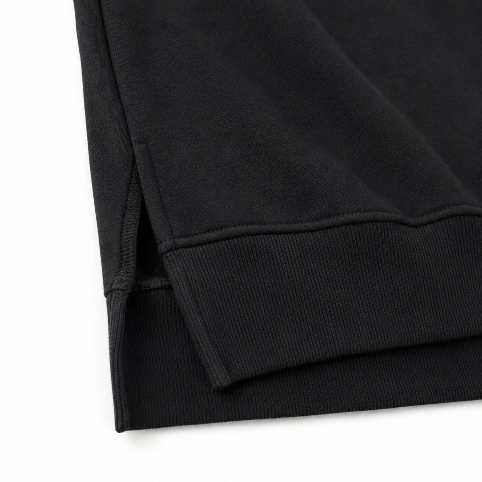 Close-up of the FineAF Iconic sweatshirt short side slit, ribbed front hem and longer rear hem.
