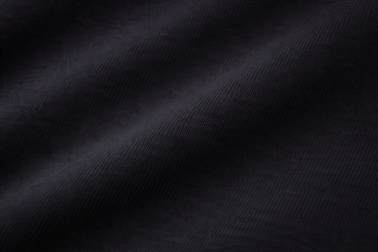 Black FineAF crewneck T-shirt fabric texture close-up showing knit and drape.