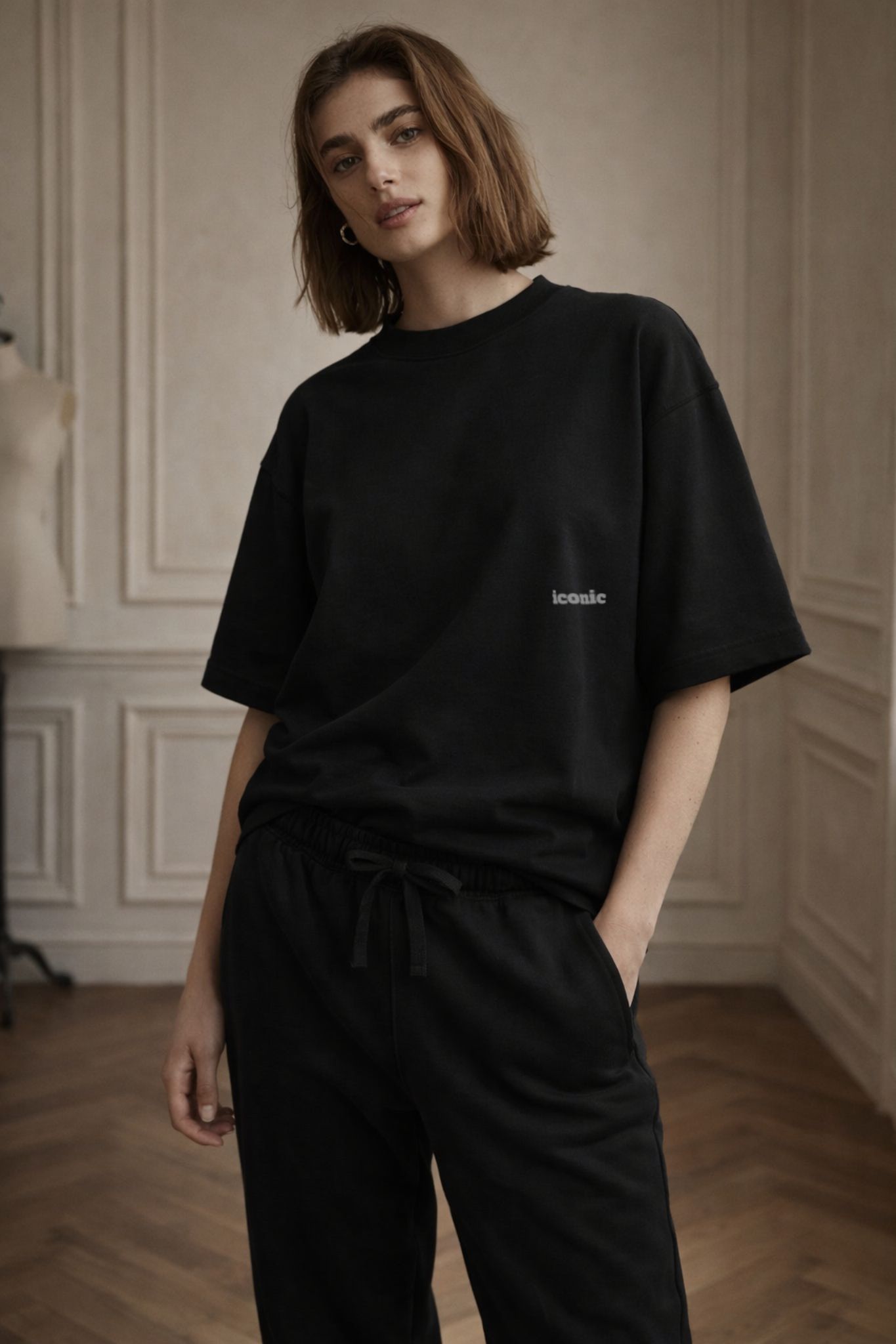 Black FineAF crewneck T-shirt with small chest logo, lifestyle full-body photo on model.
