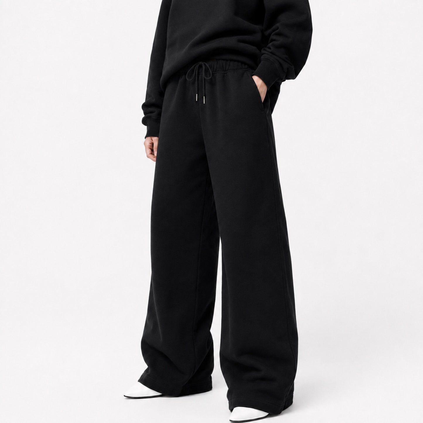 FineAF Iconic black oversized pants in a three-quarter front view showing the waistband pockets and wide legs