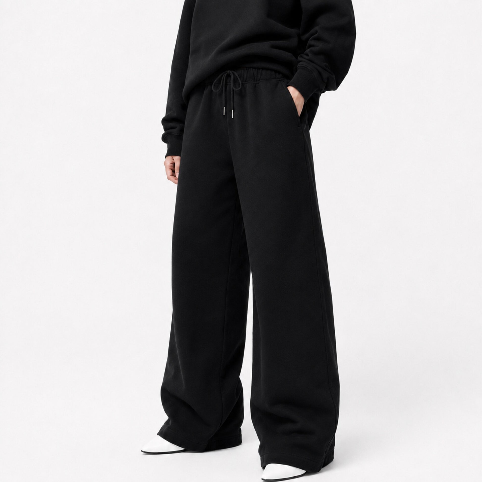 FineAF Iconic black oversized pants in a three-quarter front view showing the waistband pockets and wide legs