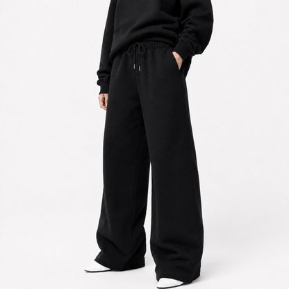 FineAF Iconic black oversized pants in a three-quarter front view showing the waistband pockets and wide legs