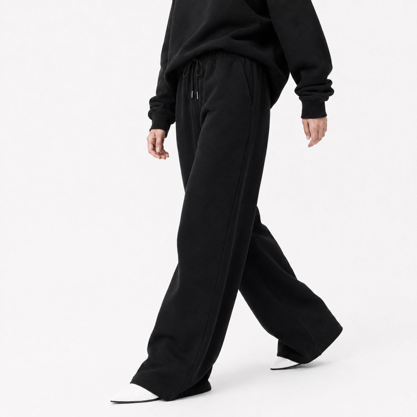 FineAF Iconic black wide straight-leg pants shown in an editorial walking pose with open hems