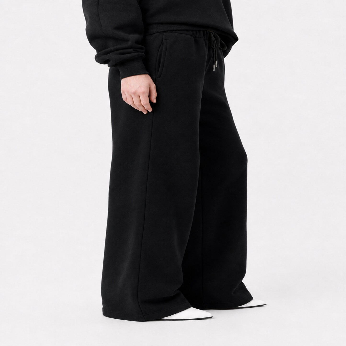Side view of FineAF Iconic black oversized pants showing the pocket side seam and structured wide leg