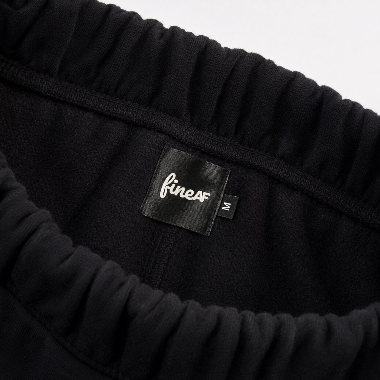 Inside waistband of FineAF Iconic black pants with brushed fleece FineAF label and M size tab