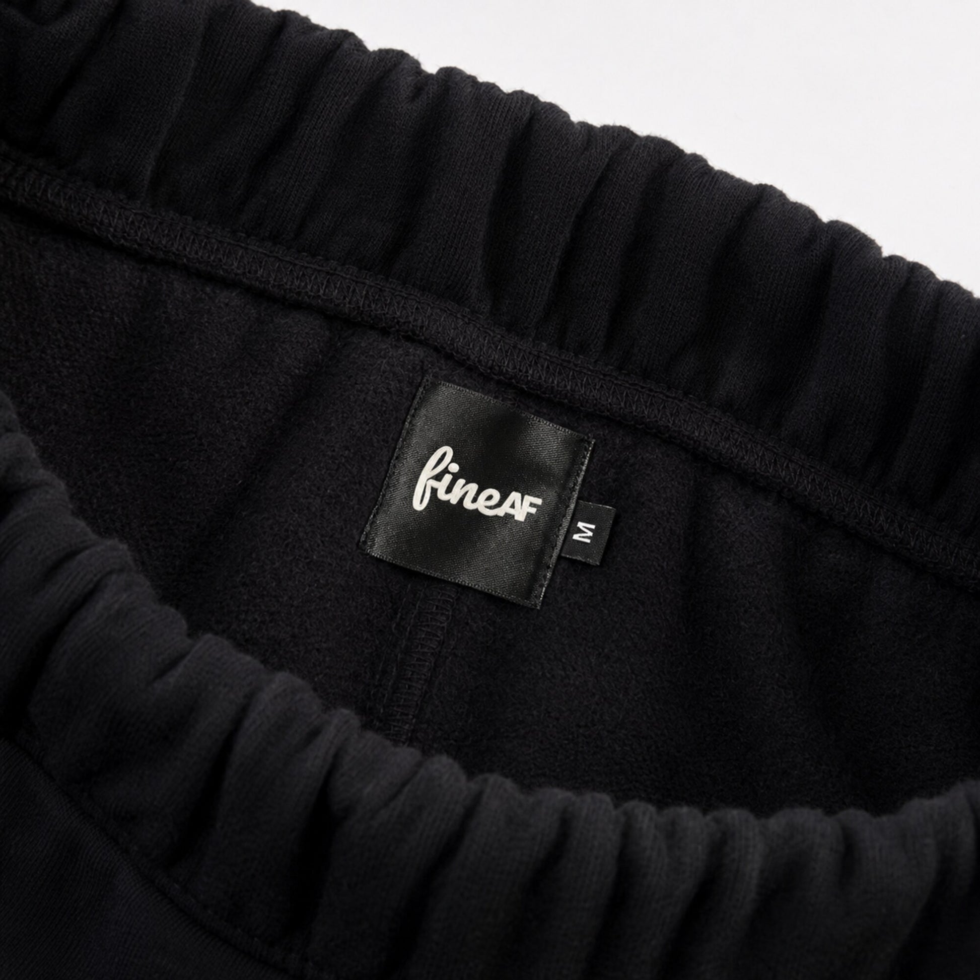 Inside waistband of FineAF Iconic black pants with brushed fleece FineAF label and M size tab