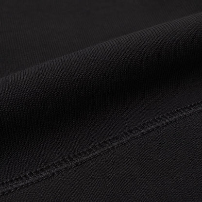 Macro view of the dense matte black fabric and tonal seam on FineAF Iconic pants