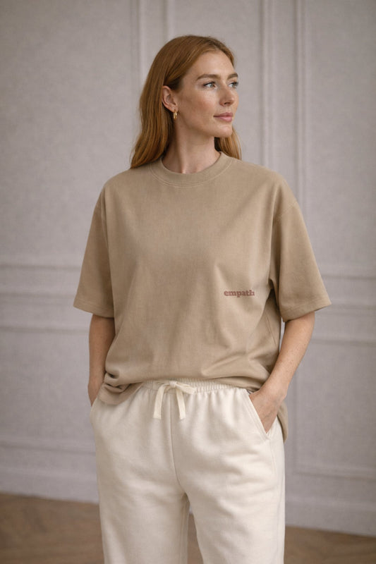 Beige FineAF crewneck T-shirt with small chest logo, lifestyle photo on model.