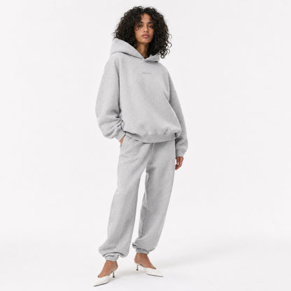 Three-quarter editorial view of the FineAF Magnetic heather grey oversized hoodie and matching joggers