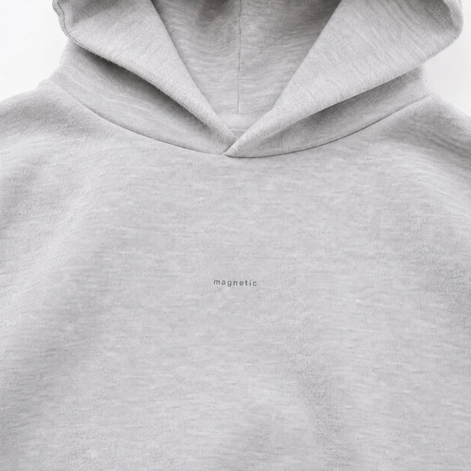Close-up of the tiny tonal magnetic design on the FineAF heather grey hoodie