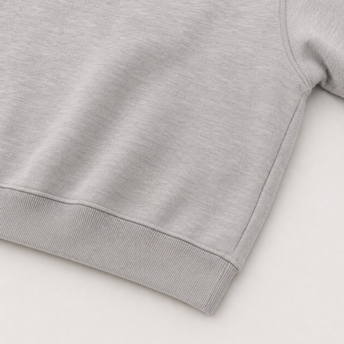 Close-up of the continuous ribbed hem and closed side construction on the FineAF Magnetic grey hoodie