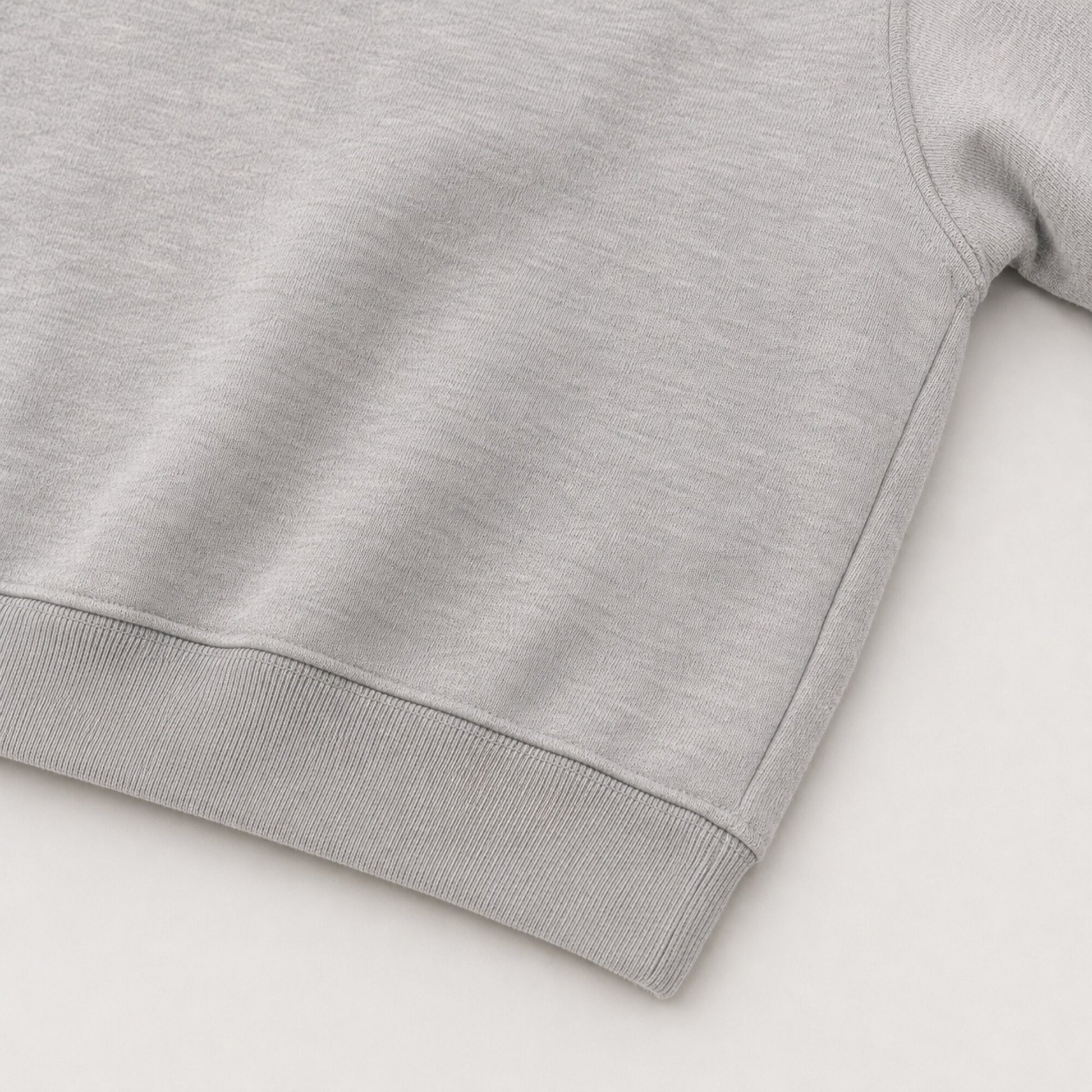 Close-up of the continuous ribbed hem and closed side construction on the FineAF Magnetic grey hoodie