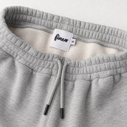 Close-up of FineAF Magnetic pants waistband, black-tipped drawcord, brushed interior and FineAF size S label