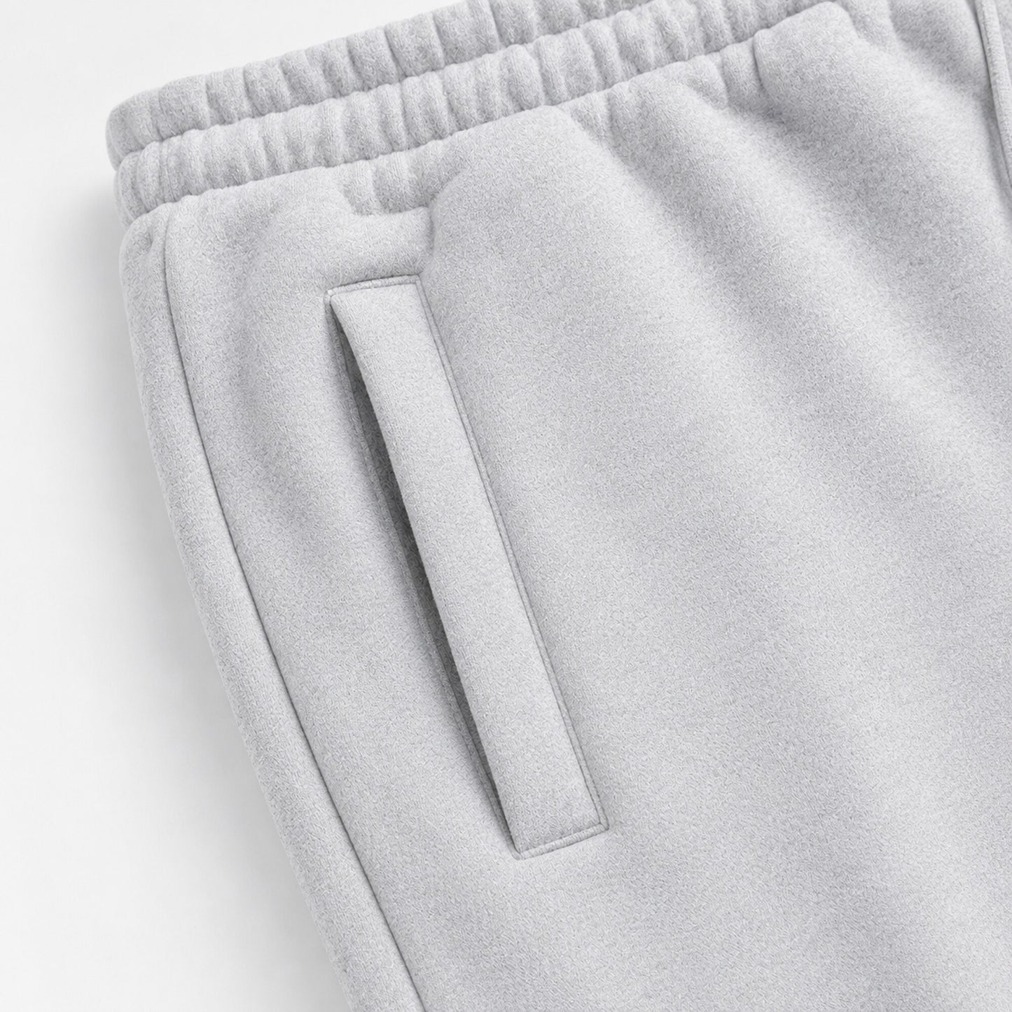 Close-up of the slanted welt pocket and gathered waistband on light grey FineAF Magnetic pants