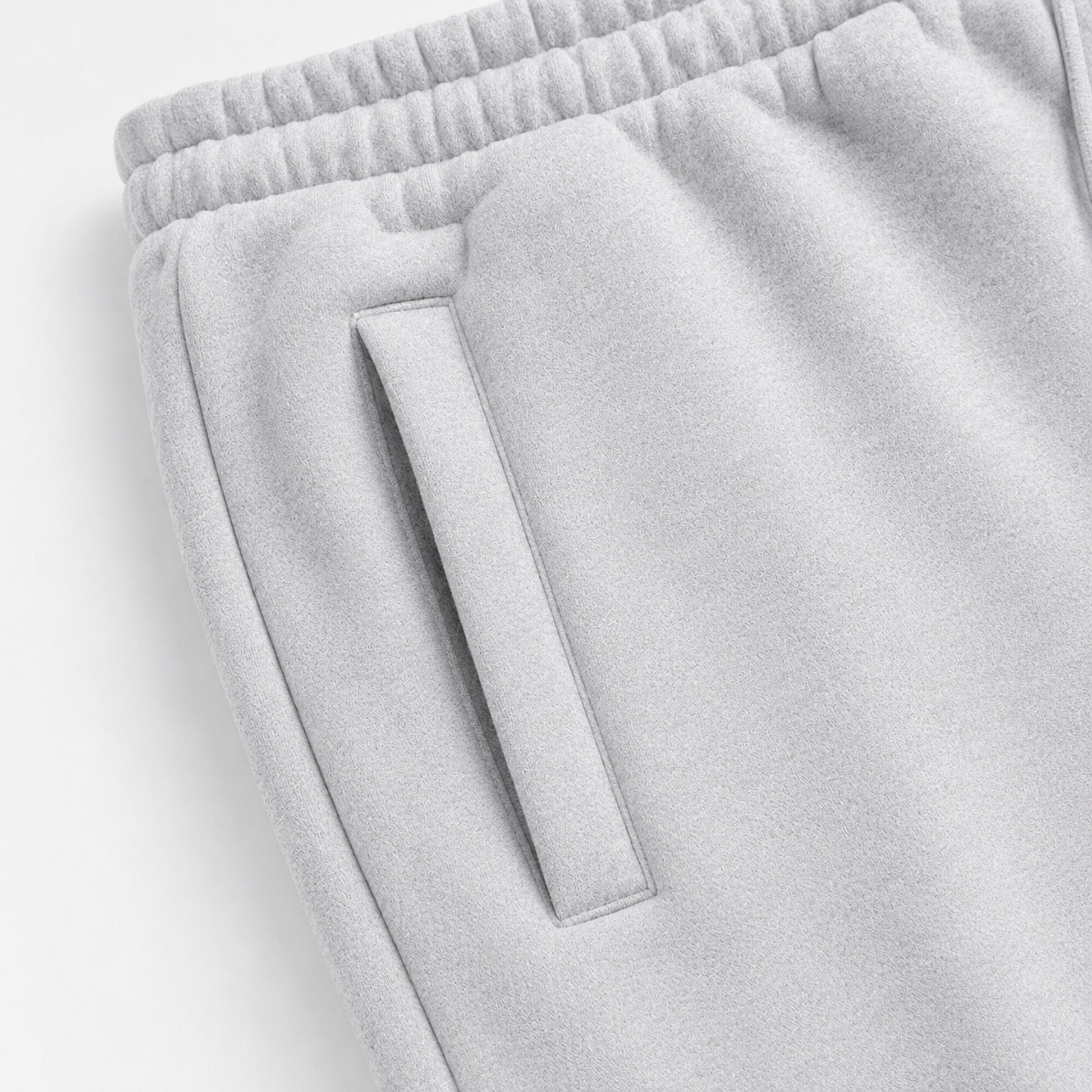 Close-up of the slanted welt pocket and gathered waistband on light grey FineAF Magnetic pants